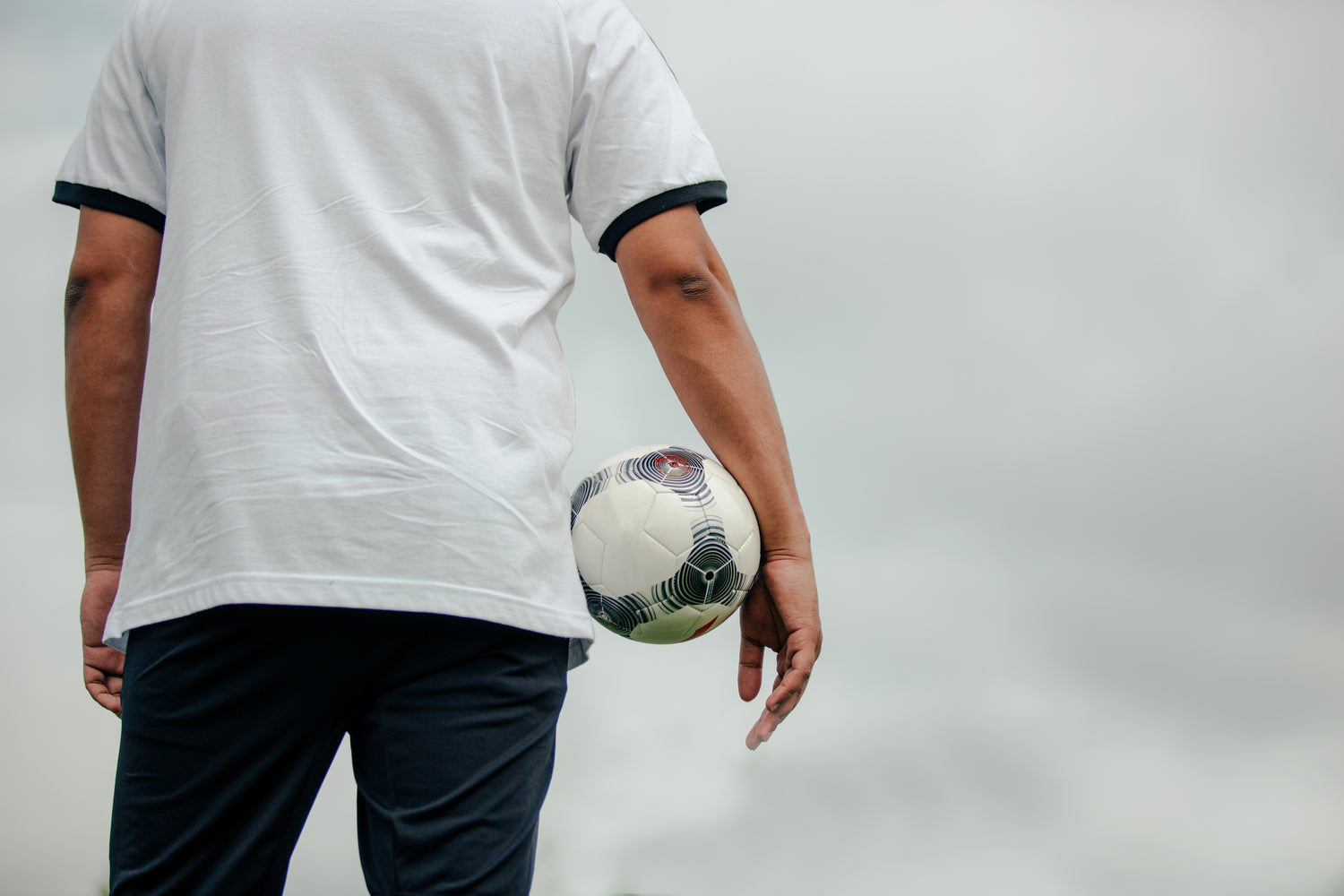 Man facing away holding soccer ball